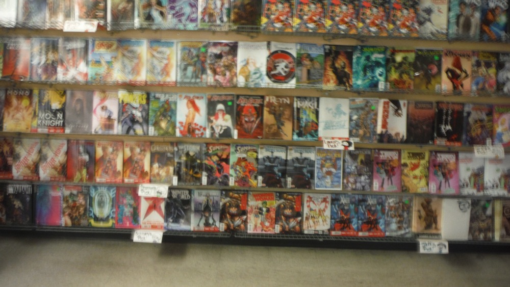 Where the Good Stuff is: the back wall of the shop has the rack of all the new comics for the week.